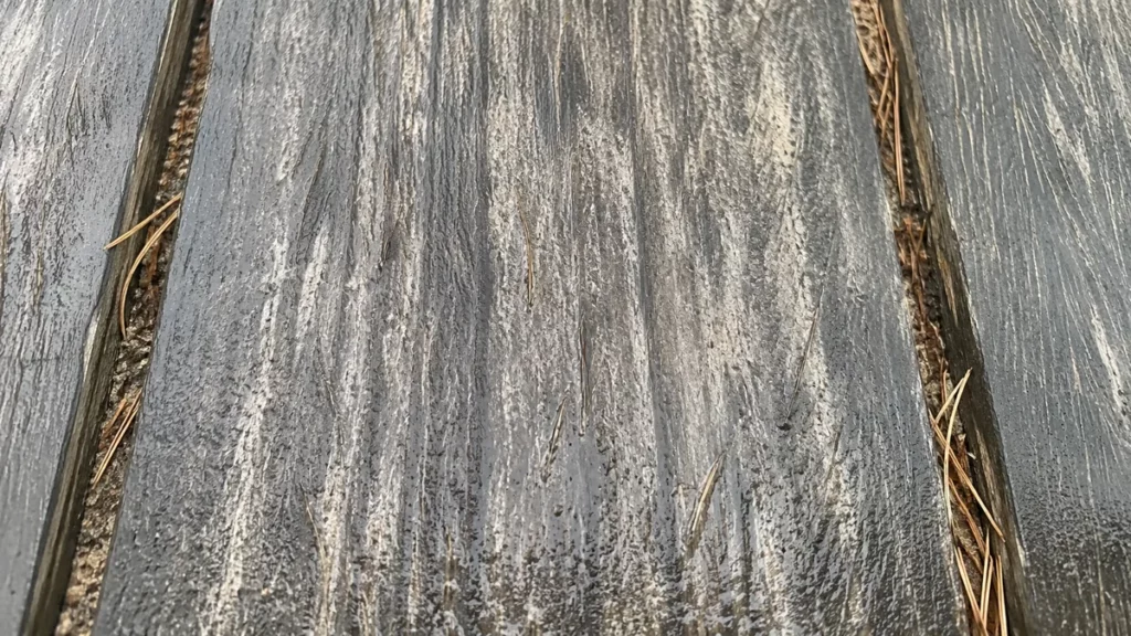 Fibres de bois relevées sur une lame de terrasse après un passage au nettoyeur haute pression