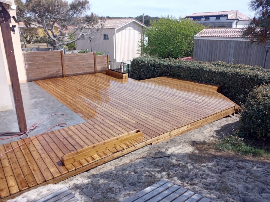 Grande terrasse en pin fermée par des claustras